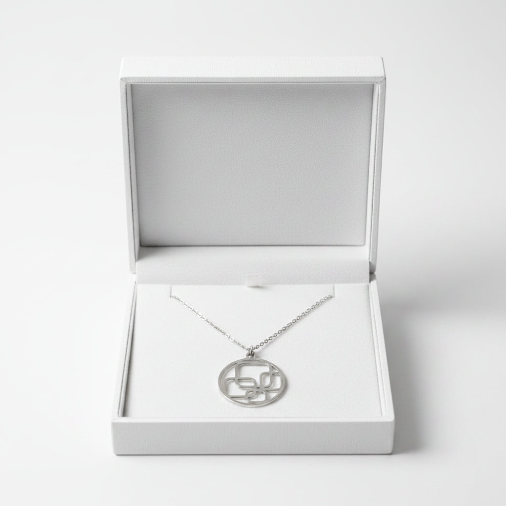 A silver pendant necklace with an abstract interlocking geometric design inside a circle, displayed in a gift box.