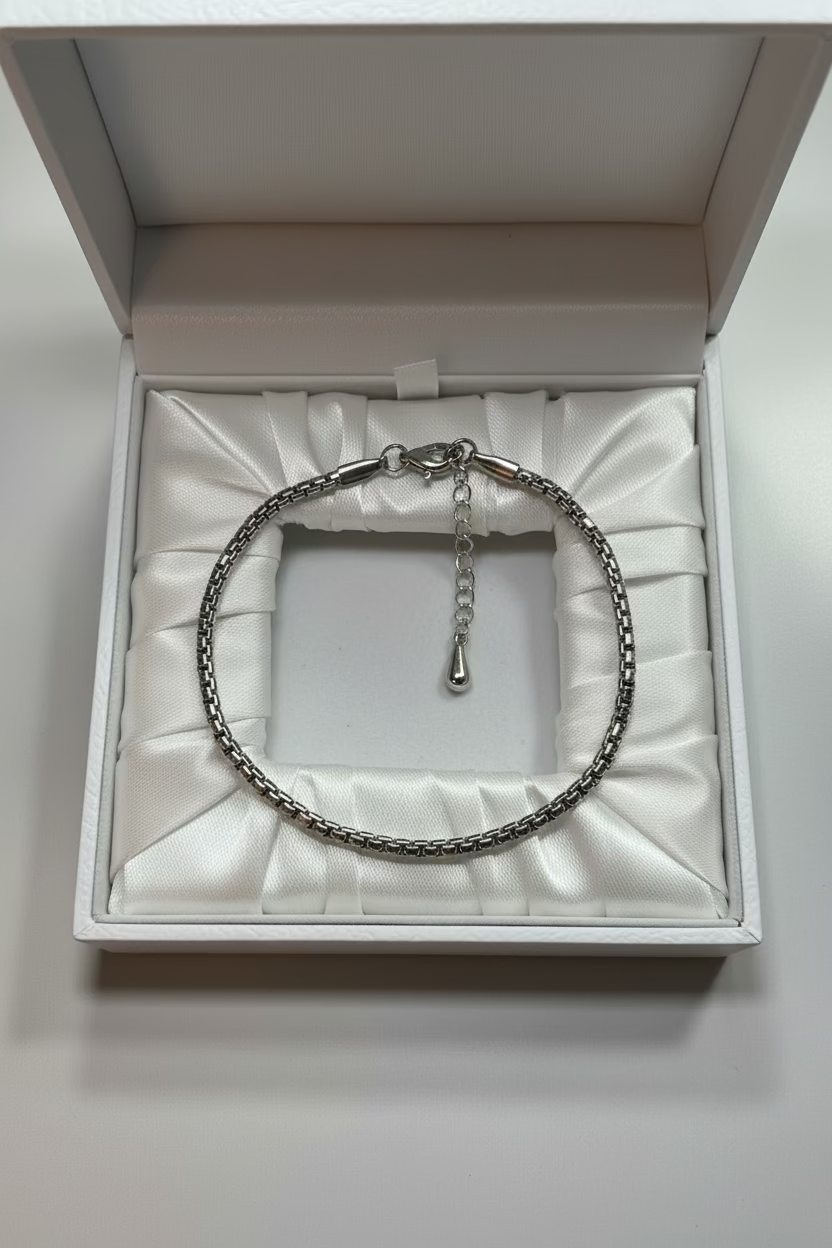 Silver chain bracelet on a light gray background