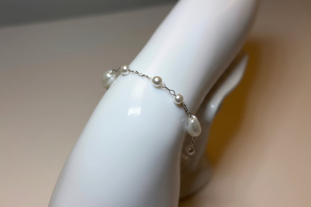 Pearl bracelet on a mannequin arm with a neutral background