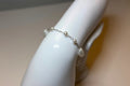 Pearl bracelet on a mannequin arm with a neutral background