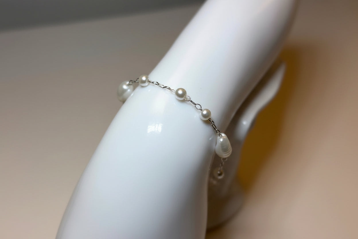 Pearl bracelet on a mannequin arm with a neutral background