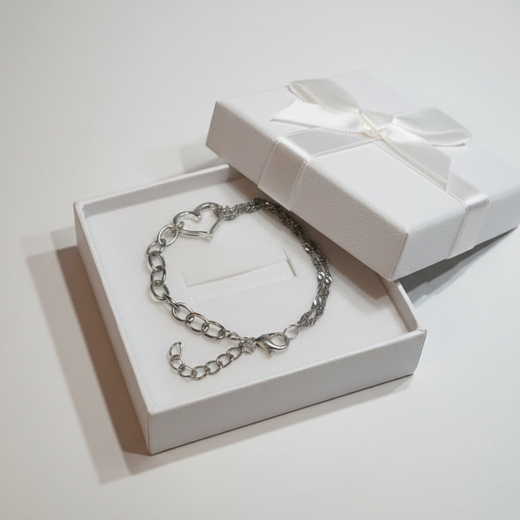 Silver chain bracelet with a heart-shaped charm in a large white gift box