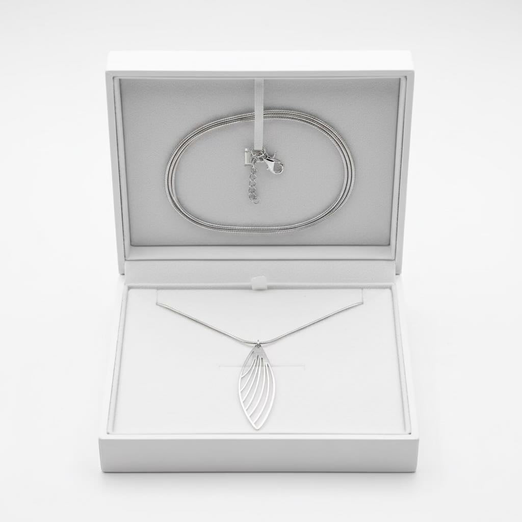 A silver necklace with a feather wing-shaped pendant displayed inside an open white jewelry box, with a matching silver chain bracelet coiled at the top of the box.