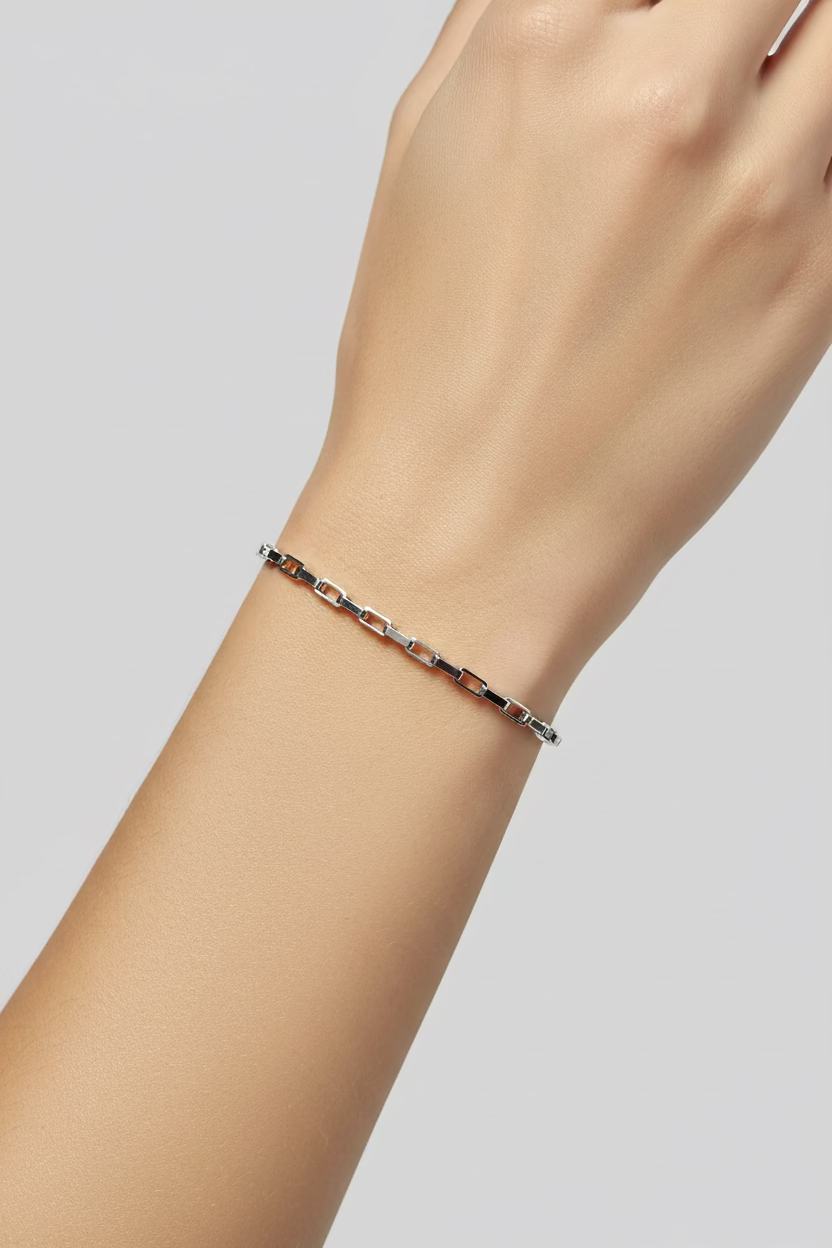 Silver bracelet on a white mannequin arm against a neutral background