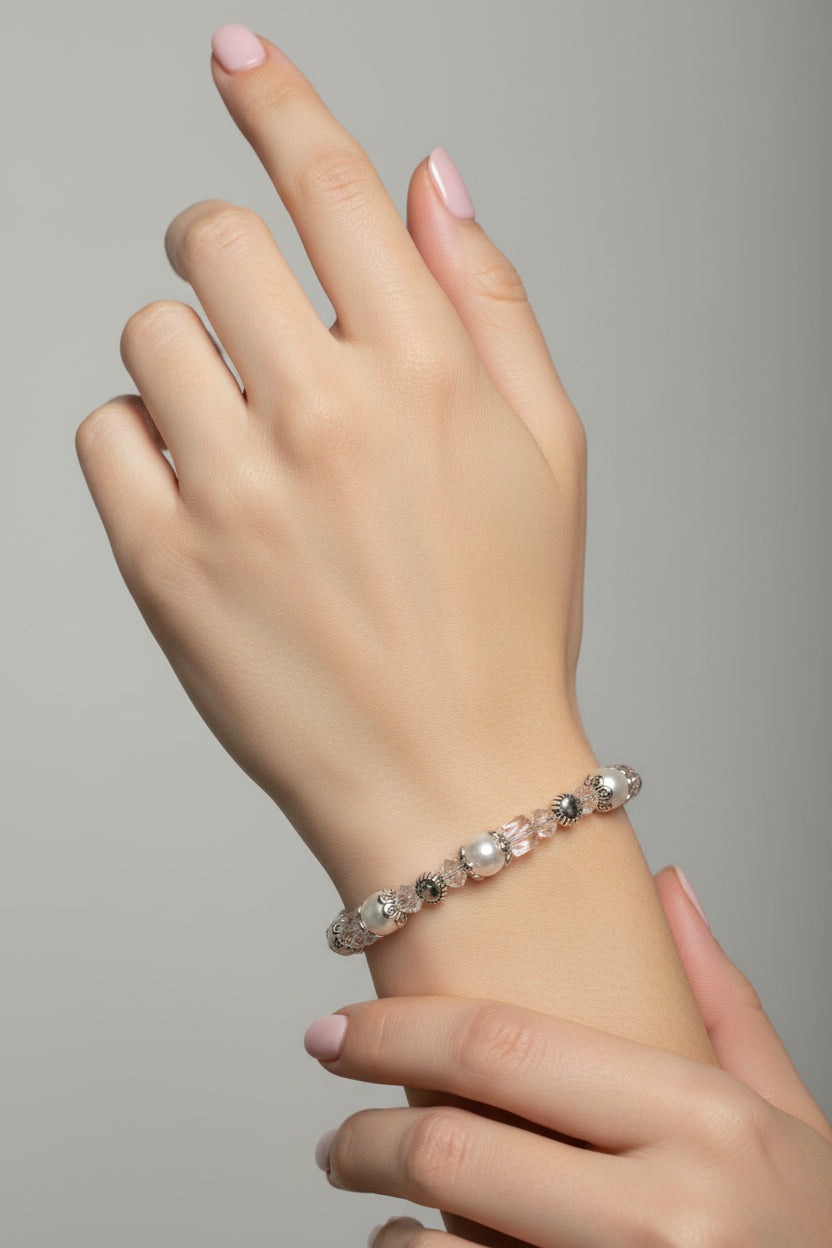 Bracelet with pearls and crystals on a mannequin arm against a neutral background