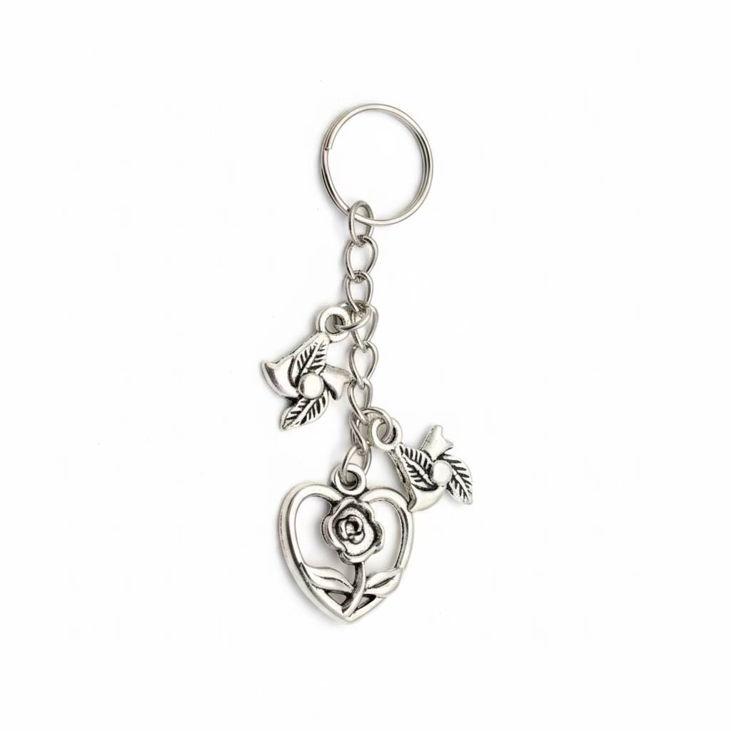 A silver-toned metal keyring/keyrings featuring a heart-shaped rose charm, and a leaf charm attached to a split key ring, shown on a plain white background.