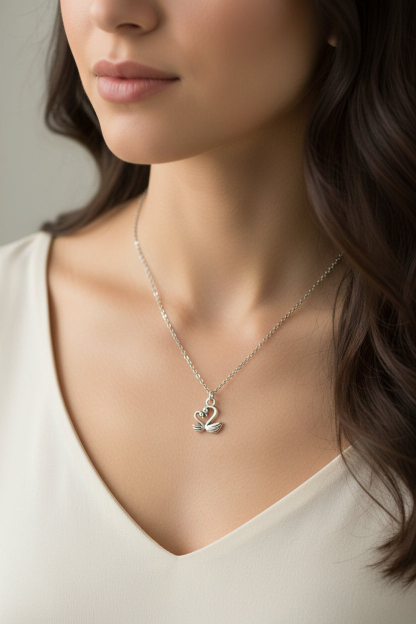 Necklace with a swan pendant worn by a model on a plain background