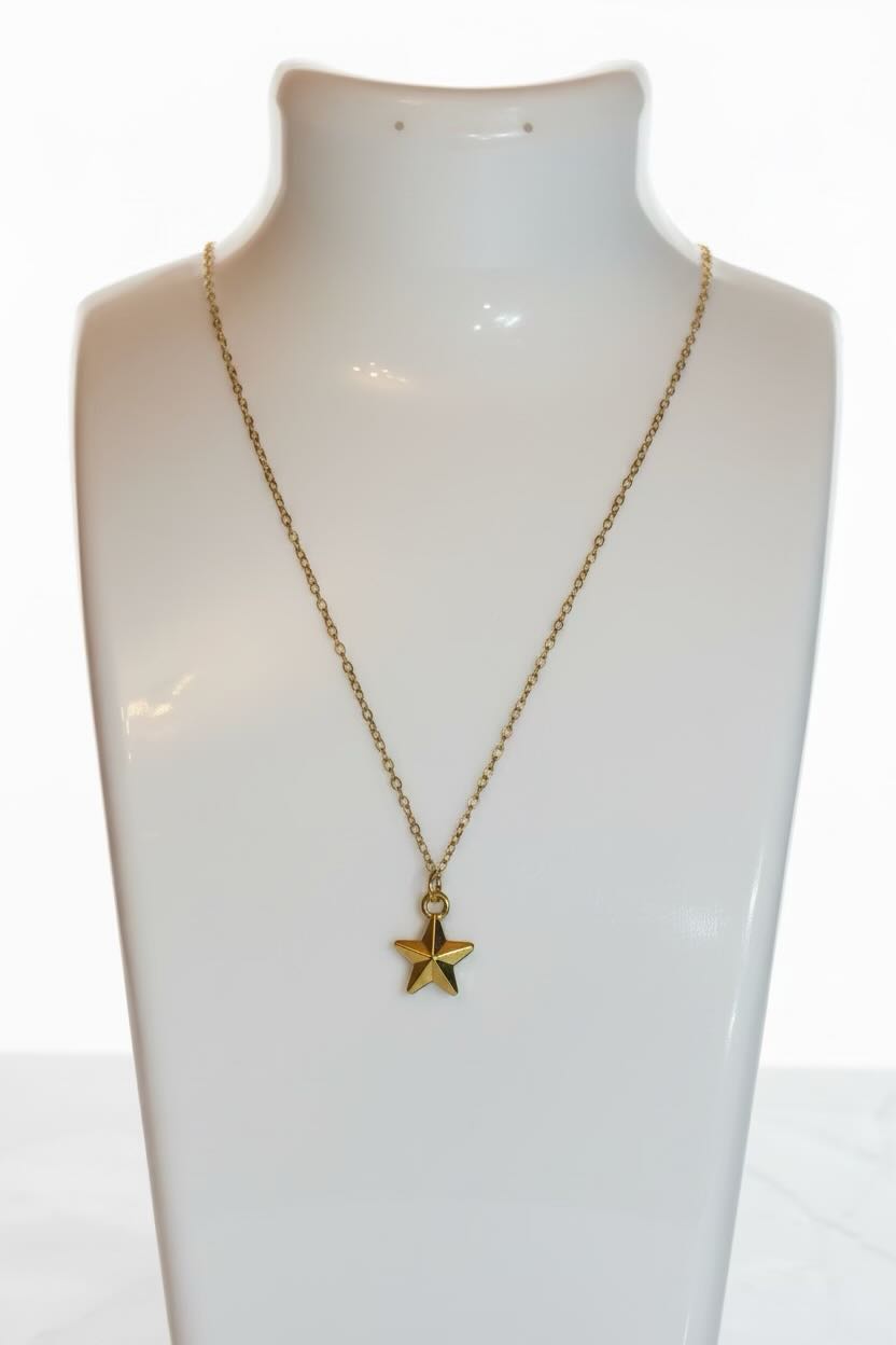 A gold 3D star pendant necklace displayed on a white jewelry bust against a white background.