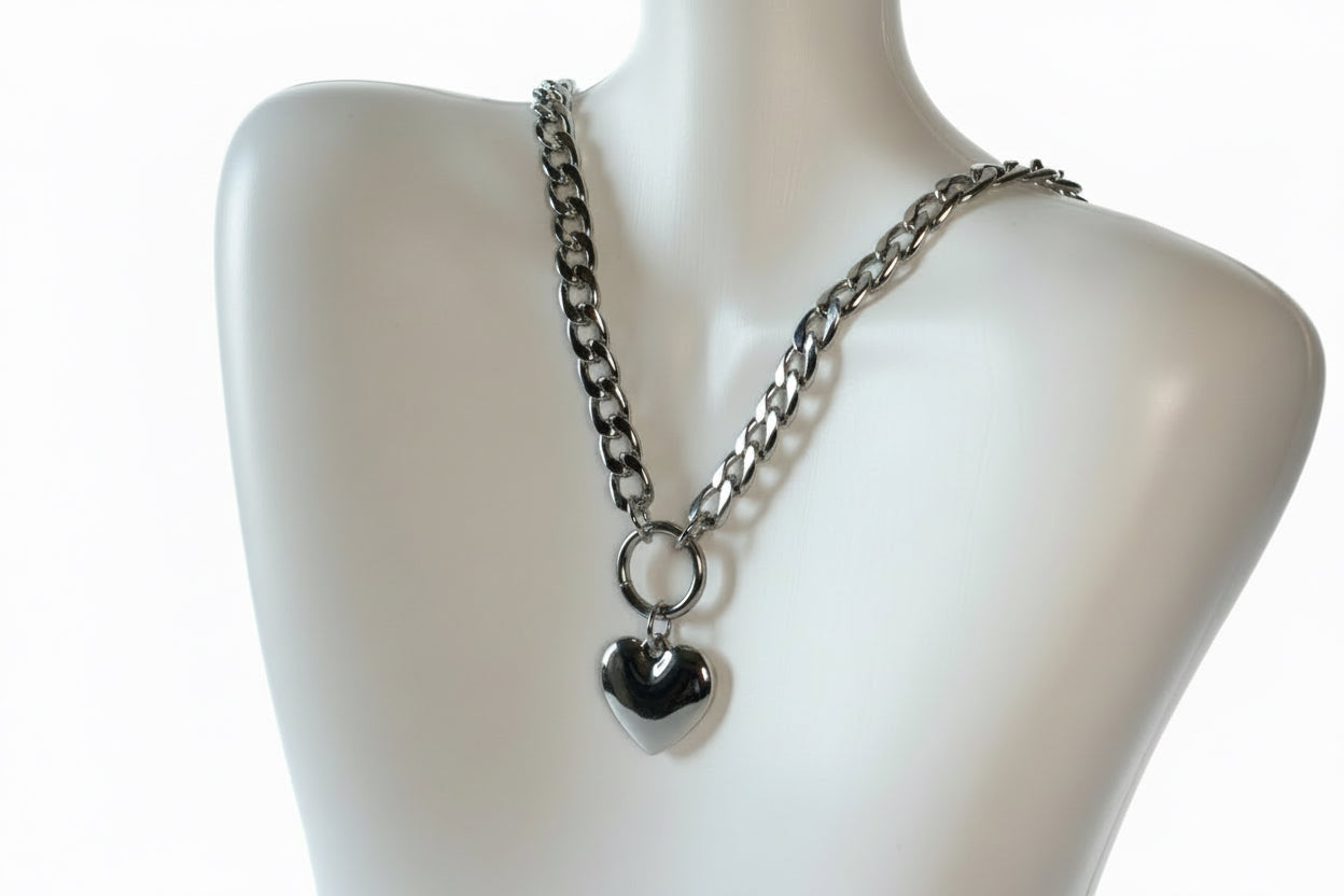 Silver chain necklace with a heart pendant on a mannequin.