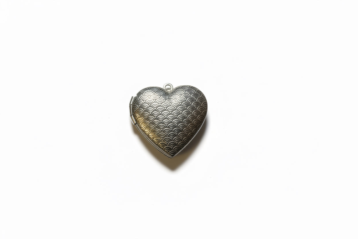 Heart-shaped metallic pendant on a white background