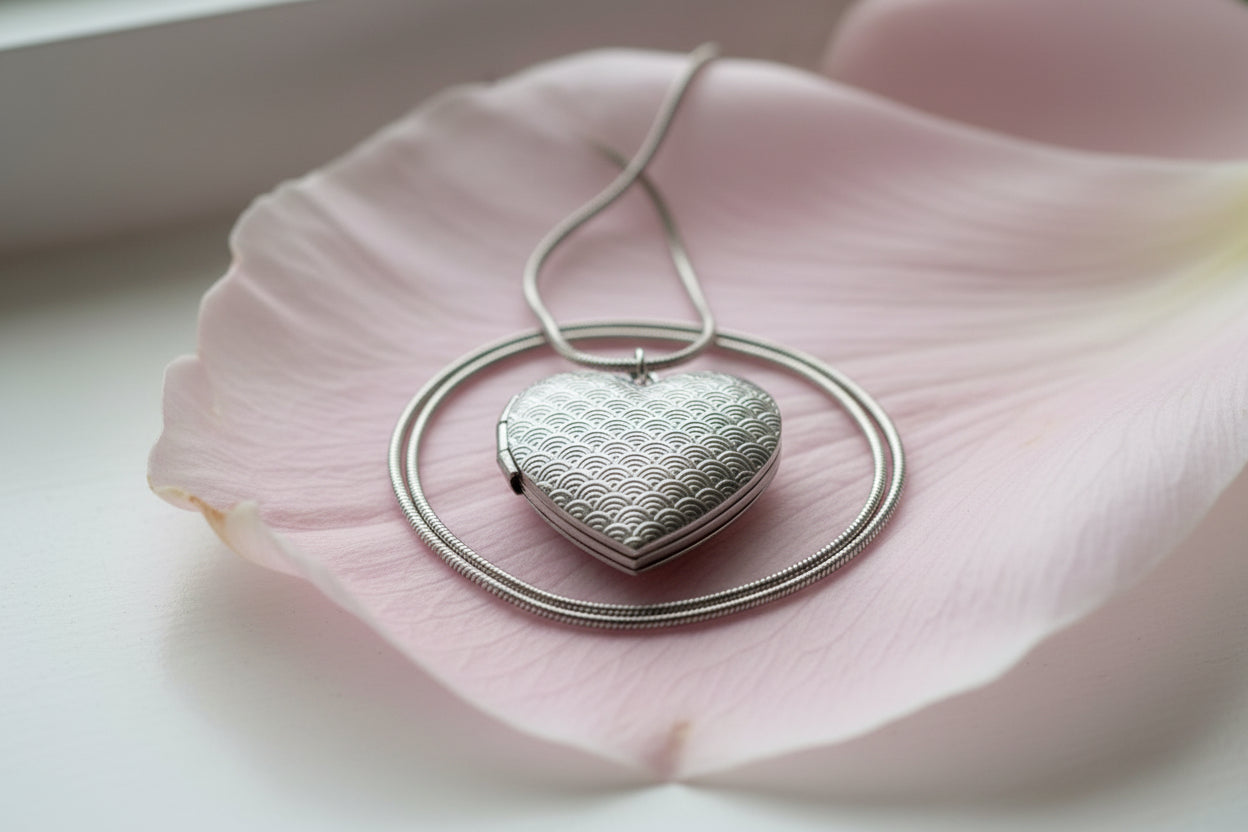 Silver heart-shaped pendant on a pale pink petal