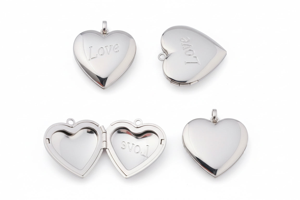 Heart-shaped silver locket with 'LOVE' engraving on a white background