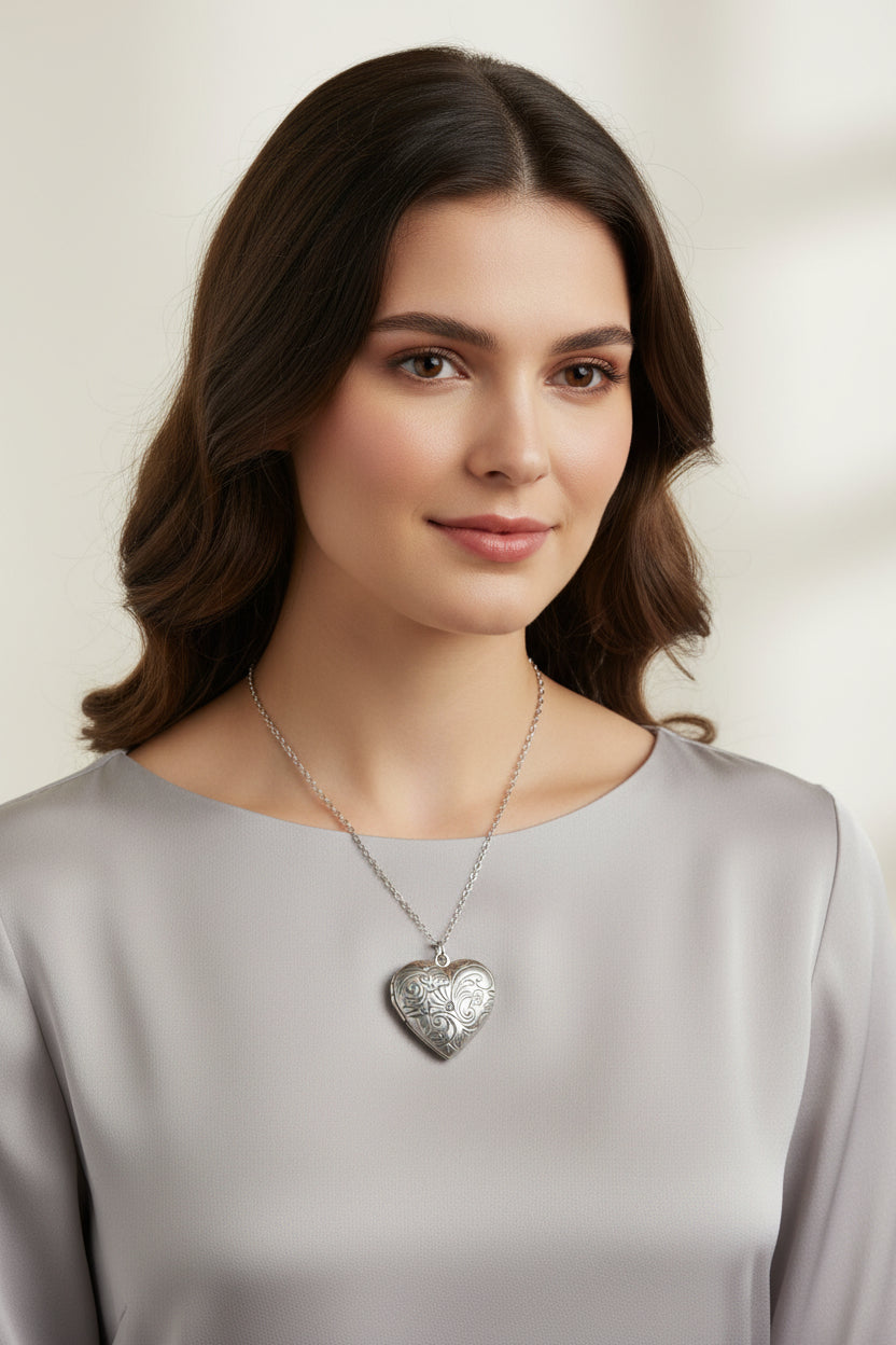 Silver heart-shaped locket on chain link necklace on a model