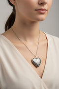 Silver heart-shaped locket necklace on a model