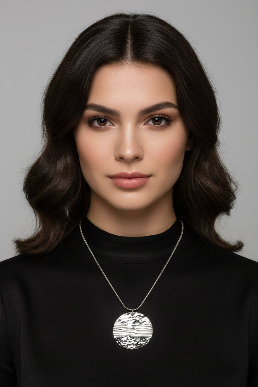 Silver necklace with a round geometric circle pendant on a model