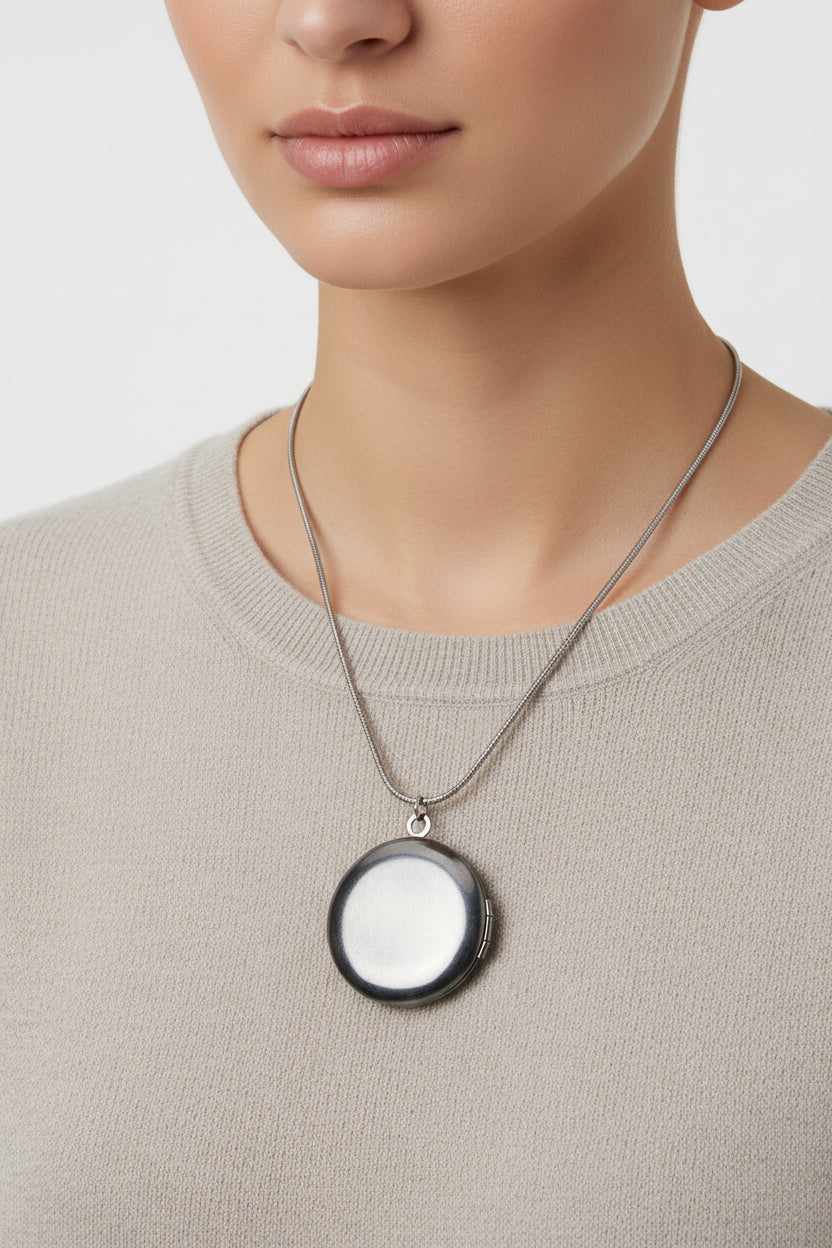 silver round locket on a stainless steel snake chain necklace on a model