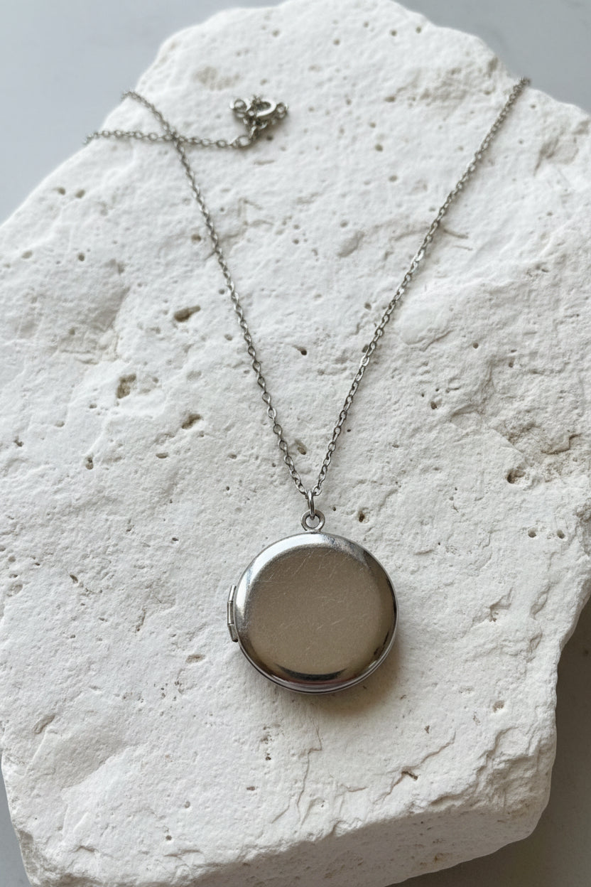 Silver necklace with a round locket on a large stone