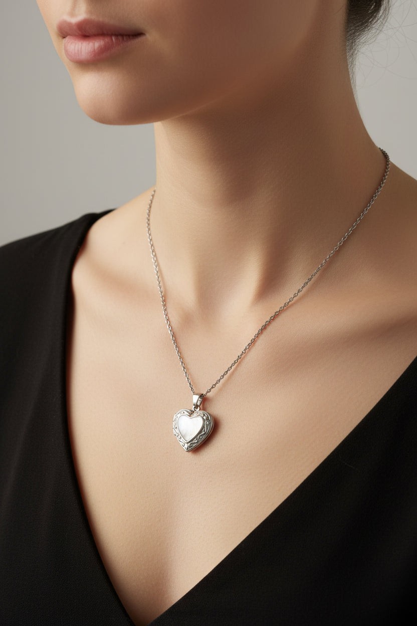 Silver chain link necklace with a heart locket on a model