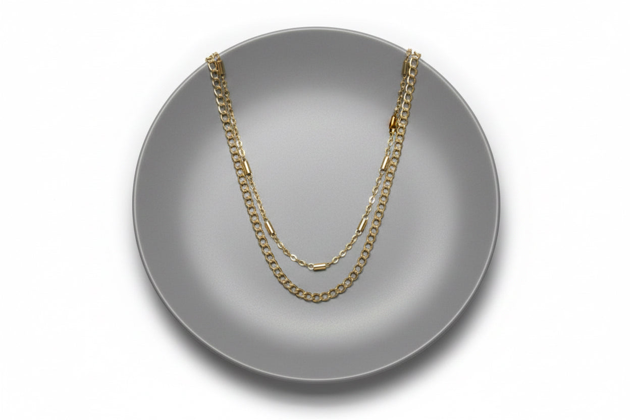 Gold chain necklace on a large grey plate