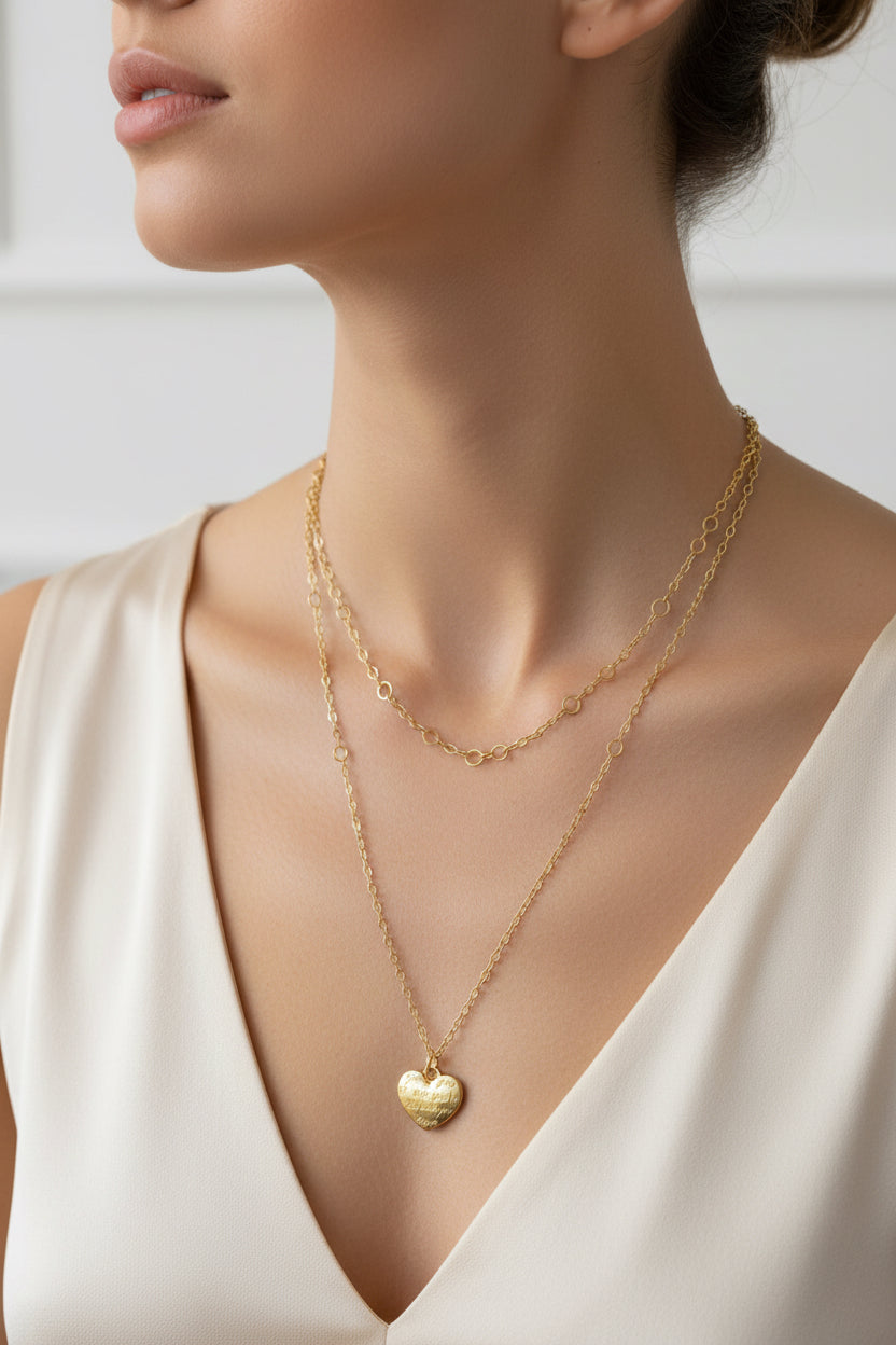 Gold chain necklace with a heart pendant on a model