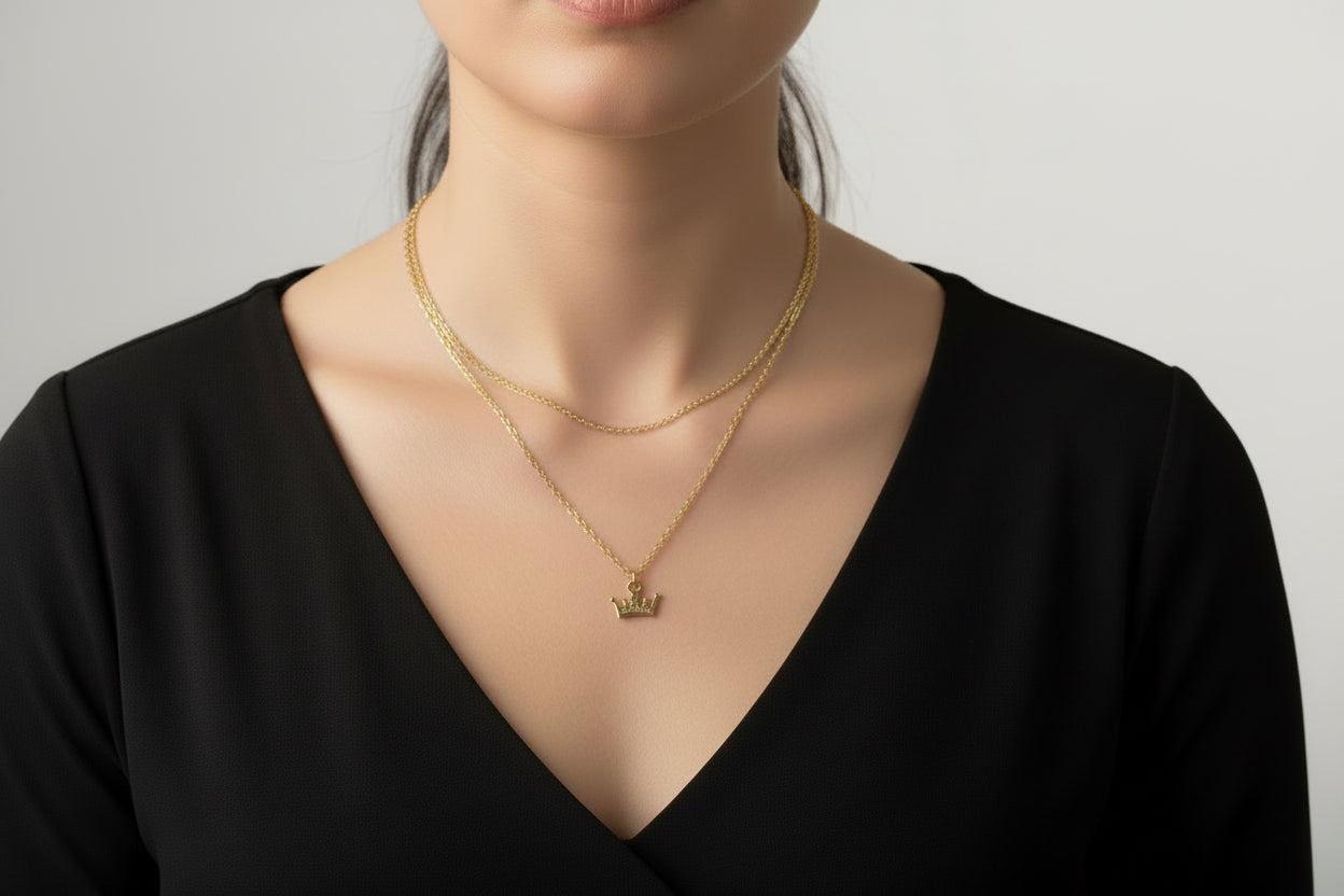 Gold necklace with a crown pendant on a model
