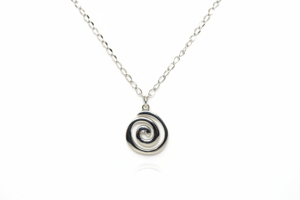 Silver necklace with a spiral pendant on a mannequin.