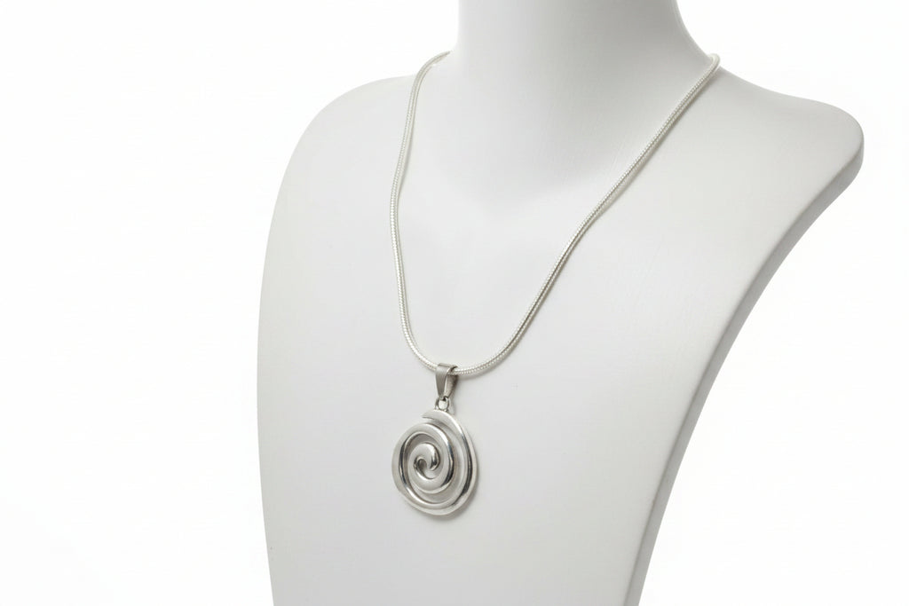 Silver spiral pendant necklace on a mannequin neck