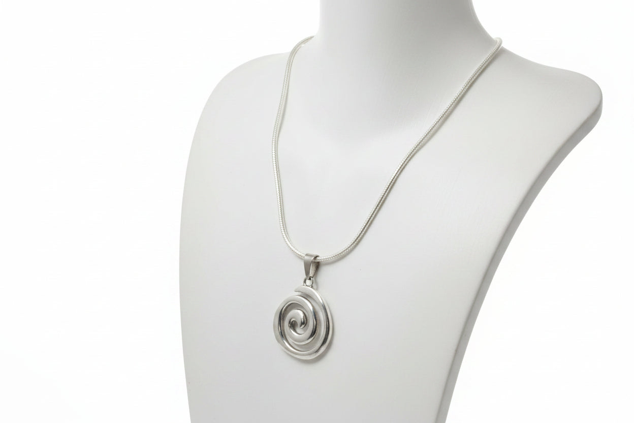 Silver spiral pendant necklace on a mannequin neck