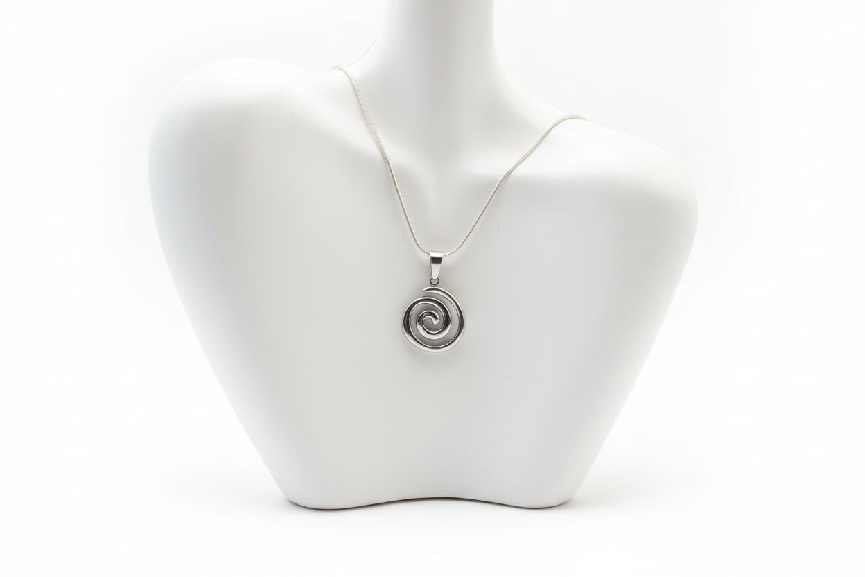 Silver spiral pendant necklace on a mannequin bust.