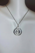 Silver spiral pendant necklace on a mannequin neck