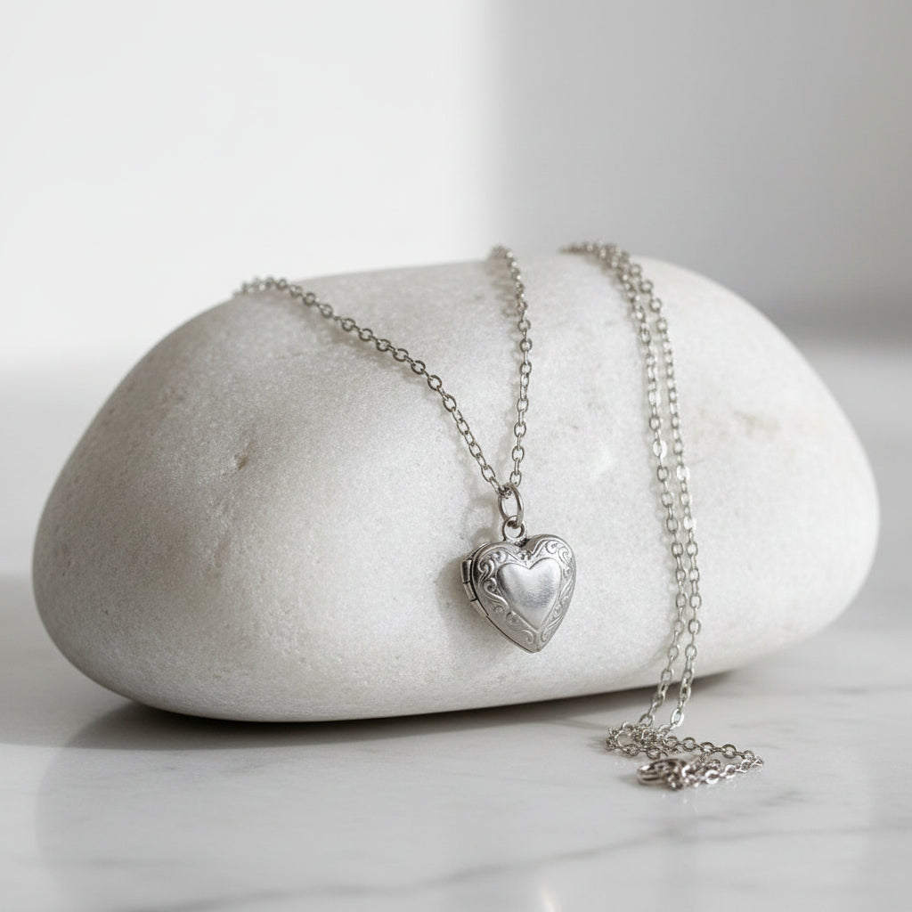Stainless steel heart-shaped locket necklace on a stone