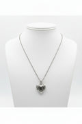 Stainless steel heart-shaped locket on chain link sterling silver necklace on a mannequin