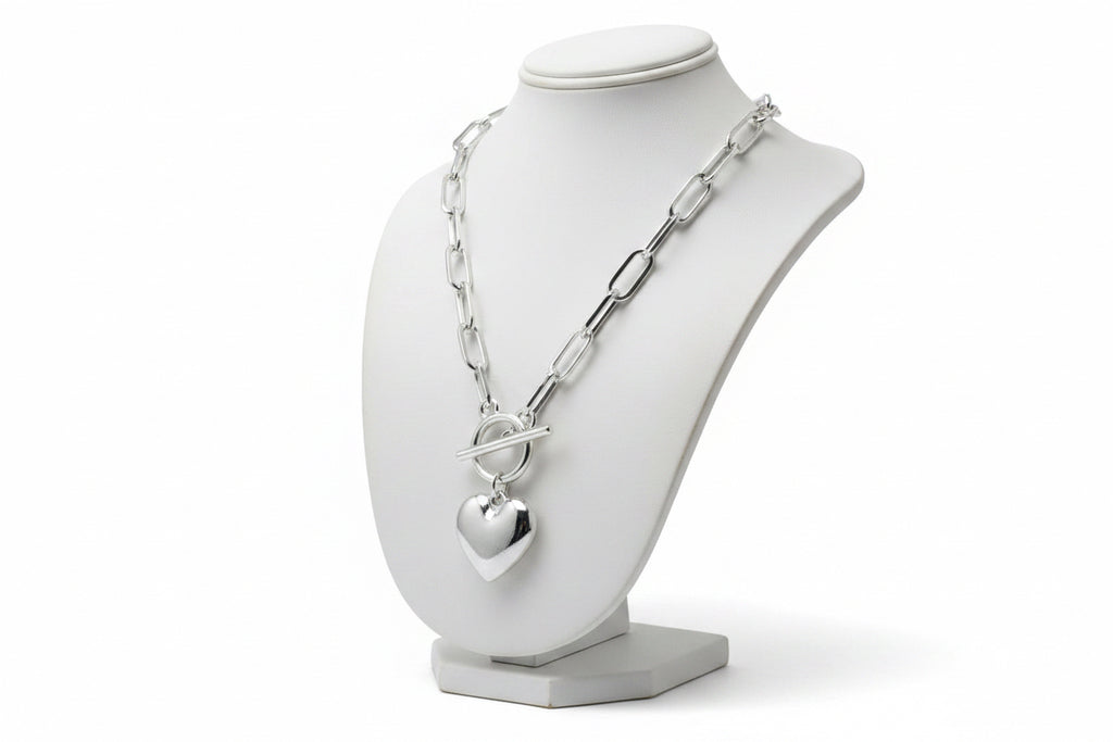 Silver necklace with a heart pendant on a mannequin.