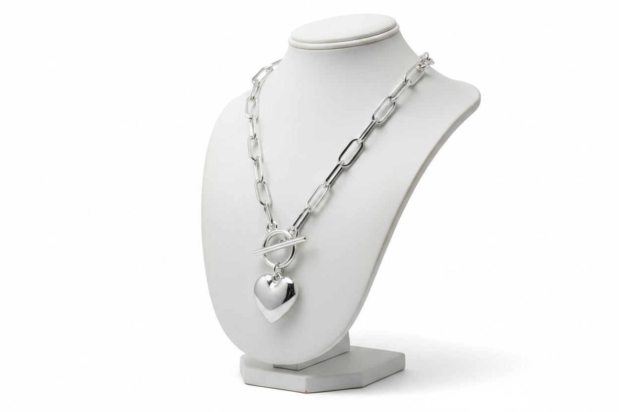 Silver necklace with a heart pendant on a mannequin.