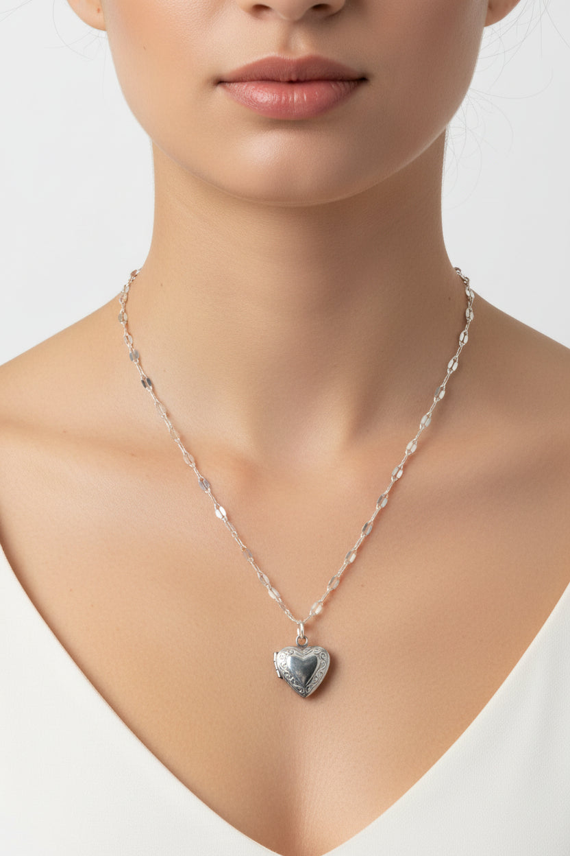 Silver lip chain necklace with a heart locket on a mode