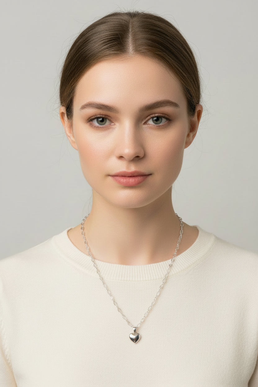 Silver heart-shaped pendant on a chain necklace displayed on a model