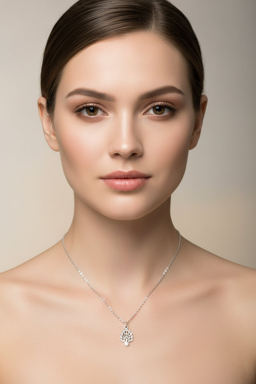 Silver necklace with a detailed pendant on a model