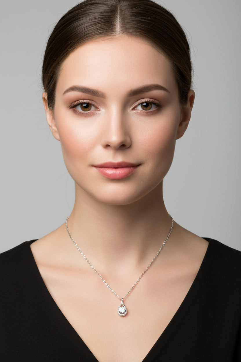 Silver necklace with a teardrop pendant on a model