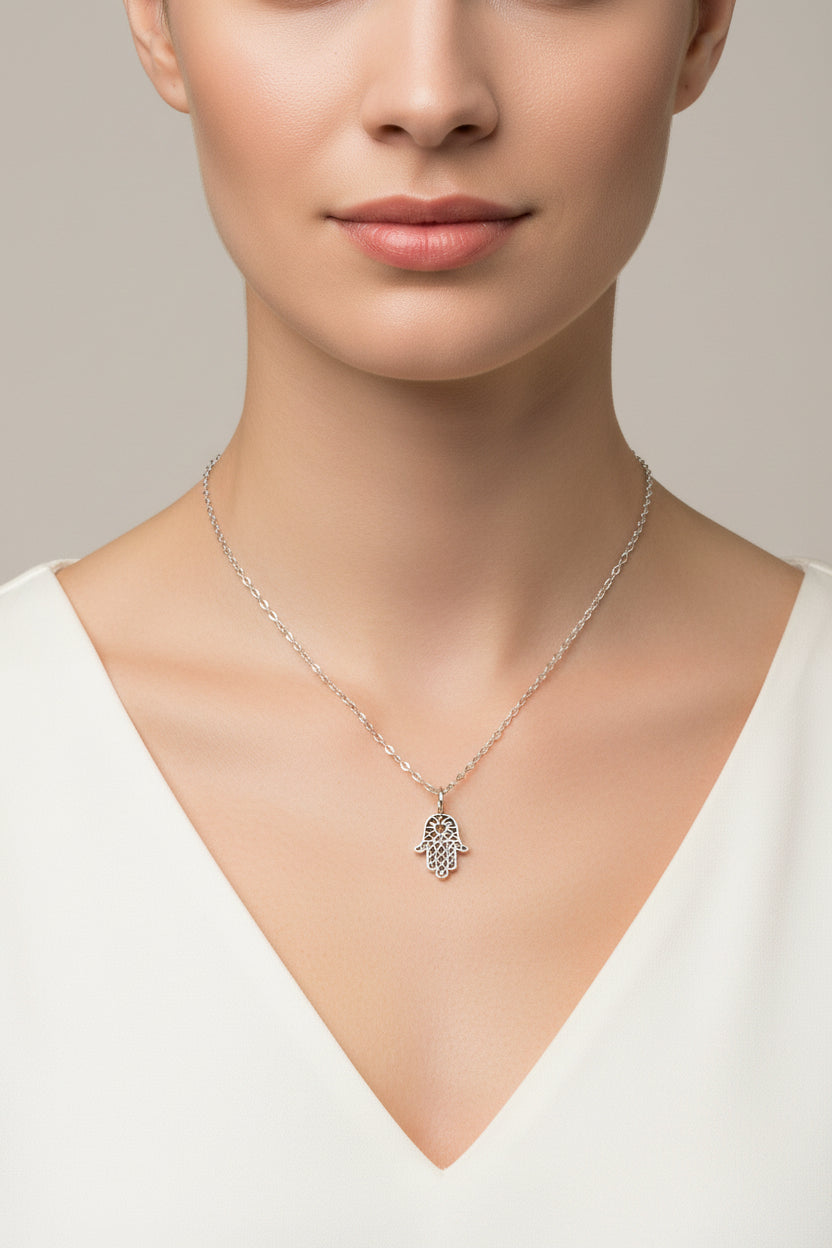 Silver necklace with a Hamsa hand pendant on a mannequin.