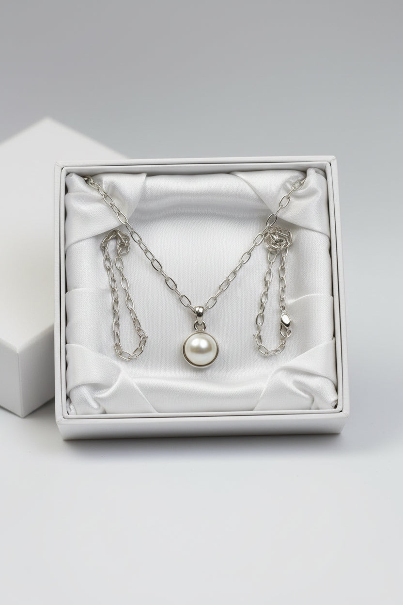 Silver necklace with a June pearl birthstone pendant in a gift box.