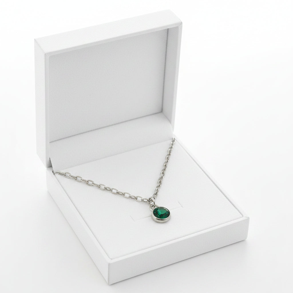 Silver necklace with a green pendant in a gift box