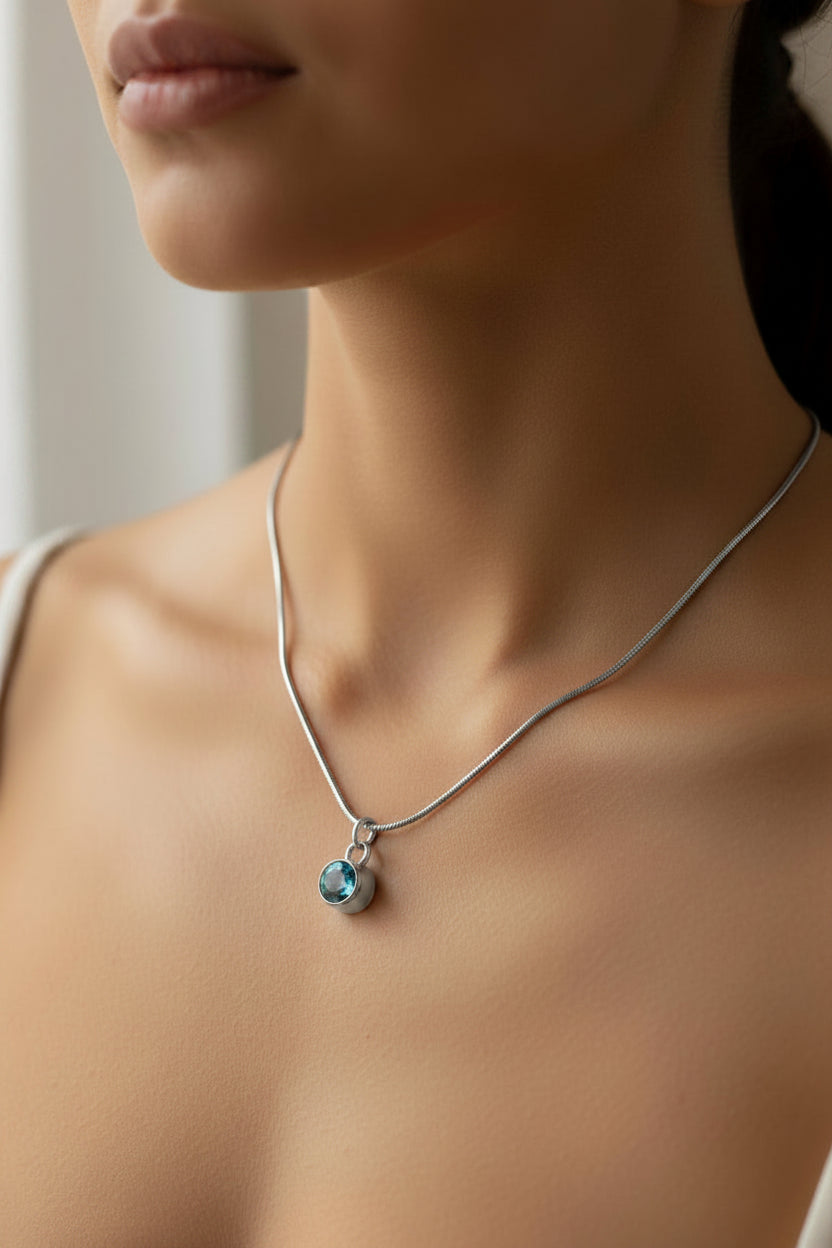 Necklace with a blue March birthstone pendant on a model