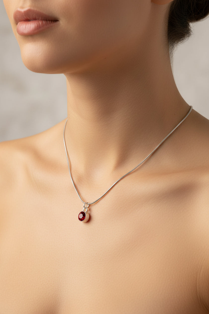 Necklace with a red January birthstone pendant on a model