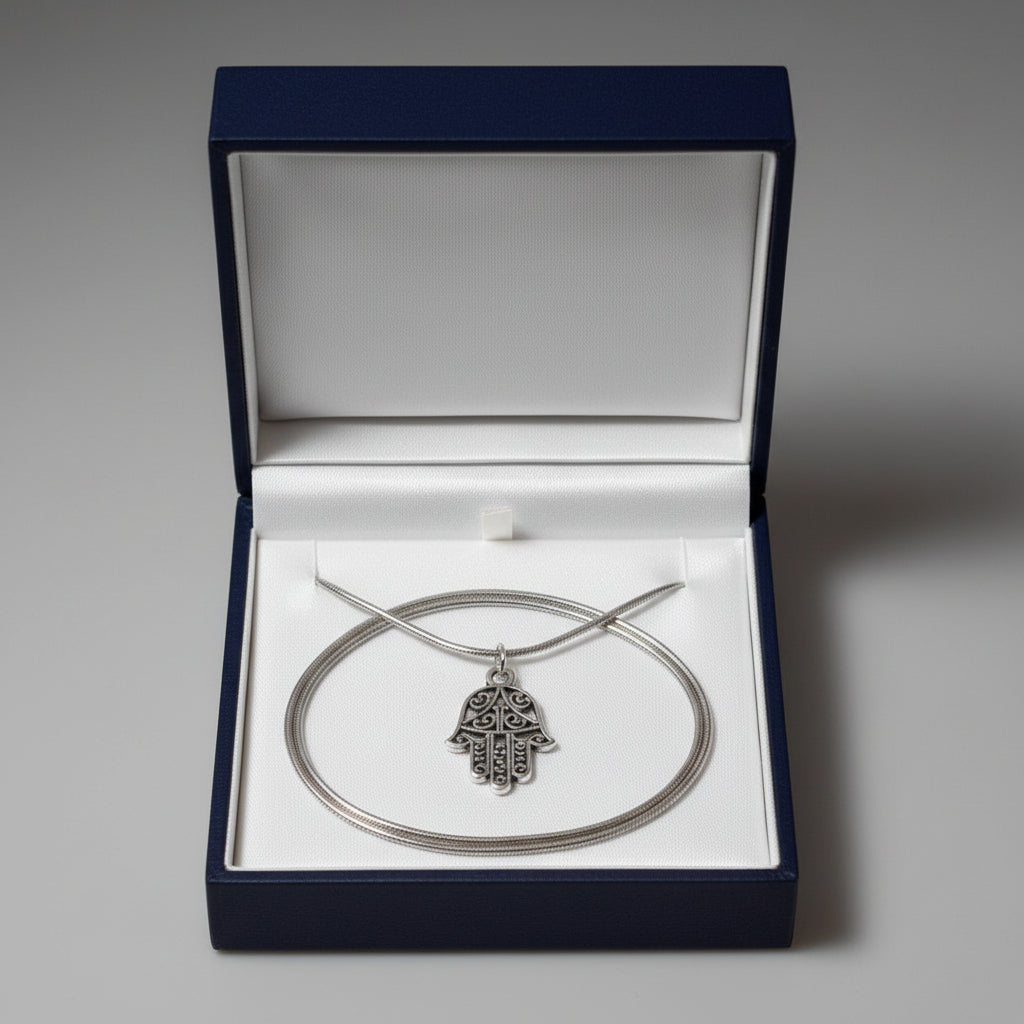 A silver-tone Hamsa hand pendant necklace displayed in a blue gift box with a plain background.