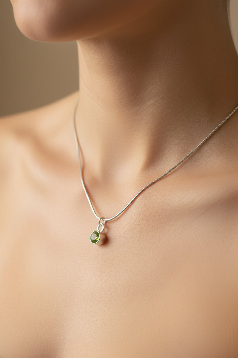 Necklace with a green pendant on a model's neck