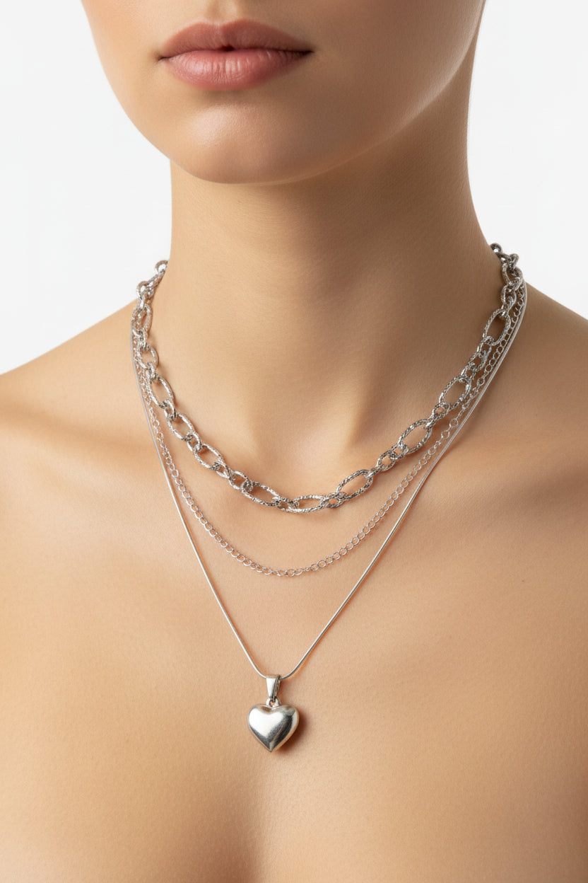 Triple silver necklace set with a heart pendant on a model