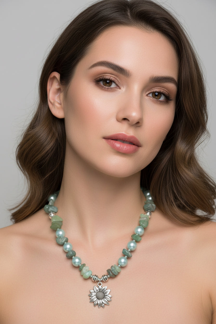 Necklace with green beads and a silver sunflower charm on a model