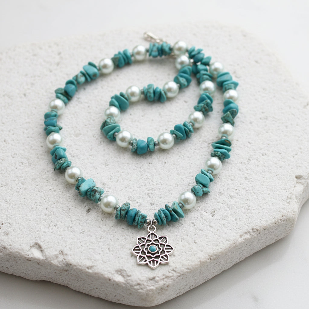 Necklace with turquoise and pearl beads on a white stone surface