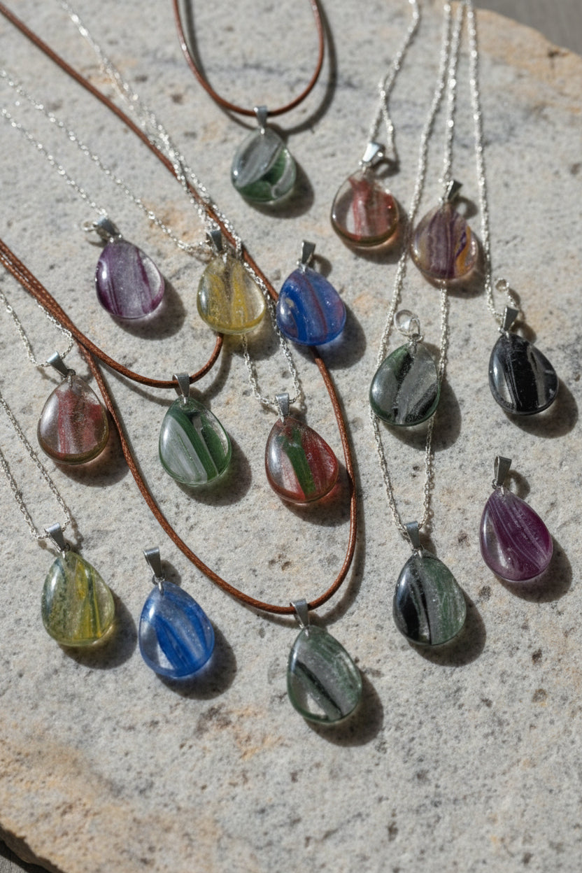 Teardrop-shaped pendants in various colors on a gray background
