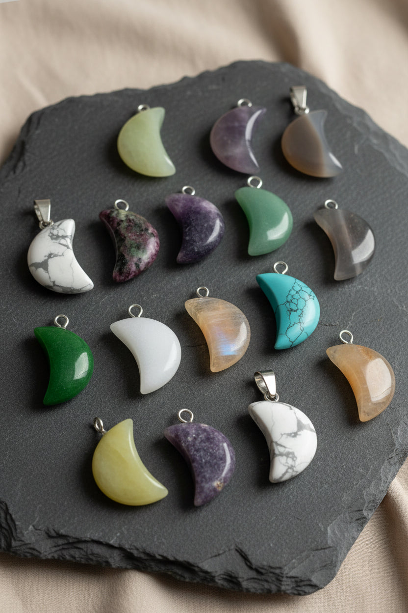 Collection of variously colored moon-shaped pendants on a large black stone
